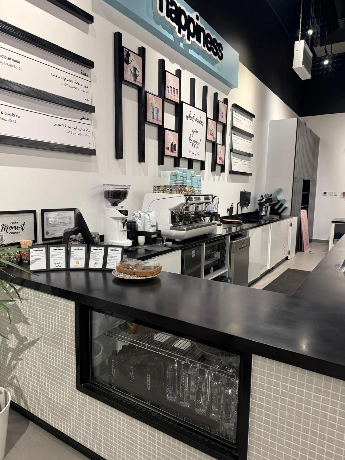 inside happiness Bahrain with the menu wall and coffee counter